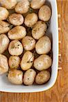 Roasted baby potatoes with thyme, olive oil and salt on baking sheet