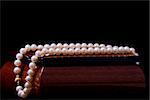 Pearl necklace on the jewelry box on a black background