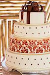 Layered white wedding cake with chocolate detail on silver serving dish