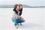 Full length side view of a casual man and son relaxing at the beach