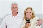 Relaxed senior couple watching television in a house