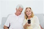 Relaxed senior couple watching television in a house
