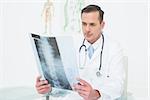 Concentrated male doctor looking at x-ray picture in the medical office