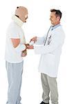 Side view of a doctor shaking hands with patient tied up in bandage over  white background