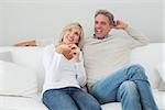 Happy man and woman sitting in living room at home