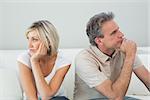 Displeased relaxed couple sitting on sofa after a fight in a house