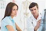 Male doctor explaining spine x-ray to female patient in the medical office