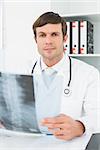 Portrait of a male doctor with x-ray picture of spine in the medical office
