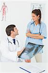 Male doctor and female surgeon examining x-ray in a medical office