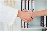 Extreme close-up of a doctor and patient shaking hands in the medical office