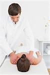 Male physiotherapist massaging woman's back in the medical office
