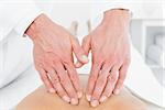 Close-up of a male physiotherapist massaging woman's back in the medical office