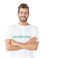 Portrait of a happy male volunteer standing with hands crossed over white background