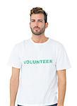 Portrait of a serious young male volunteer standing over white background