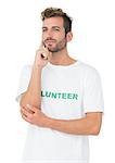 Thoughtful young male volunteer standing over white background