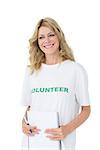 Portrait of a smiling young female volunteer over white background