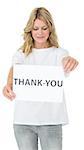 Smiling young female volunteer holding thank you paper over white background