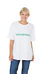 Portrait of a smiling young female volunteer standing over white background