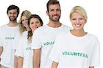 Group portrait of happy volunteers standing in a row over white background
