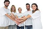 Group portrait of happy volunteers with hands together over white background