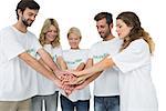 Group of young volunteers with hands together over white background