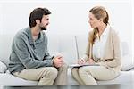 Side view of a young man in meeting with a financial adviser at home