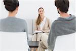 Portrait of a female financial adviser in meeting with young couple at home