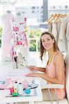 Side view portrait of a young female fashion designer working on fabrics in the studio