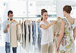 Female seller helping shopper choose the clothes in the store