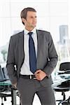 Handsome young businessman looking away in a bright office