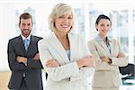 Portrait of a confident business team standing with arms crossed in a bright office