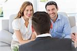Smiling young couple in meeting with a financial adviser at home