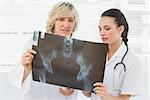 Two serious female doctors examining xray in the medical office