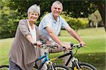Side view portrait of a senior couple on cycle ride in countryside