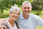 Portrait of a senior woman and man sitting at the park