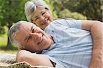 Closeup portrait of a senior woman and man lying at the park