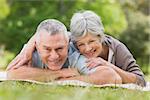 Portrait of a smiling relaxed senior couple lying in the park