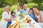 Portrait of extended family dining at outdoor table