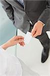 Businessman handing businesswoman his card in the office