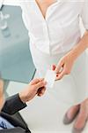 Businessman giving businesswoman his card in the office