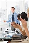 Businessman being applauded for his presentation in the office