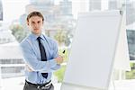 Young stern businessman standing by whiteboard in the office