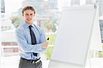 Young happy businessman standing by whiteboard in the office