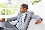 Serious businessman thinking on couch in the office