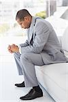 Worried businessman sitting on couch  in the office