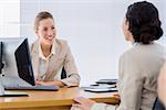 Smartly dressed young businesswomen in a business meeting at office desk