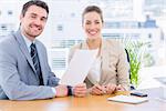 Smartly dressed young man and woman in a business meeting at office desk