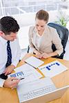 Smartly dressed young man and woman in a business meeting at office desk