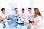 Smartly dressed executives shaking hands during a business meeting in the office