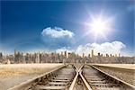 Train tracks leading to city under blue sky